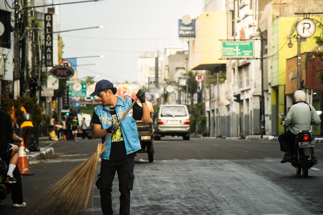 Construction workers in safety gear clearing debris on a sunny day in a Philippine city.